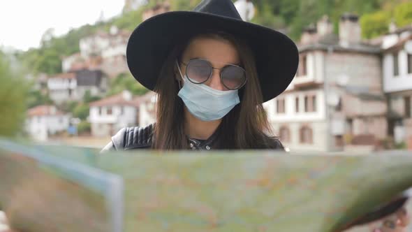 New Normal Tourist with Medical Mask on Face Using Map During Holidays