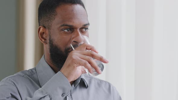 Closeup Headshot Calm Young African Ethnicity Man Drinking Glass of Fresh Pure Purified Water