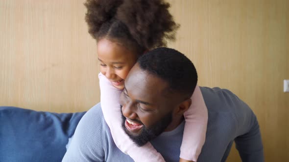 Funny Cute Kid Daughter Tickling Happy Young Father Sitting on Sofa Couch