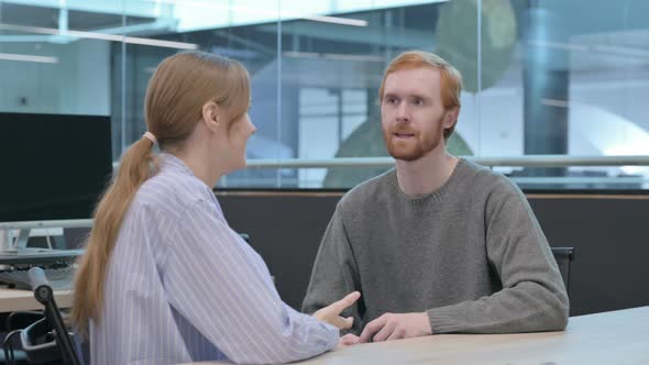 Young Man and Woman Having Conversation in Office