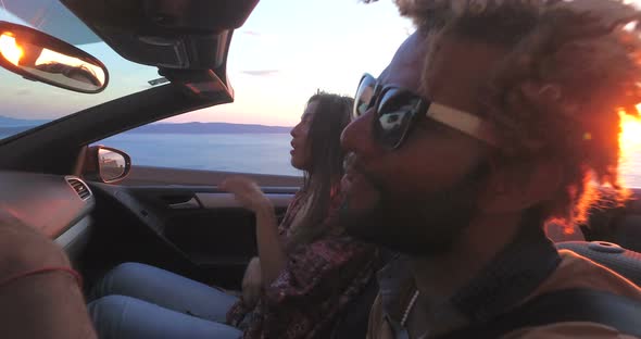 Handsome black man partying with friends while driving in convertible