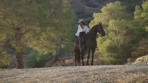 Wide Shot of Happy Equestrian and Graceful Purebred Horse Looking to Different Directions