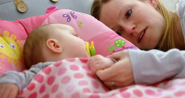 Mother putting his baby to sleep on baby bed 