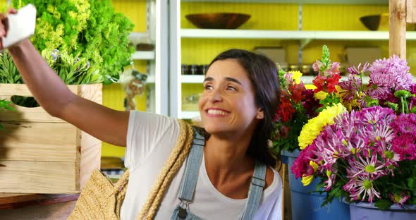 Woman taking selfie with flower from mobile phone