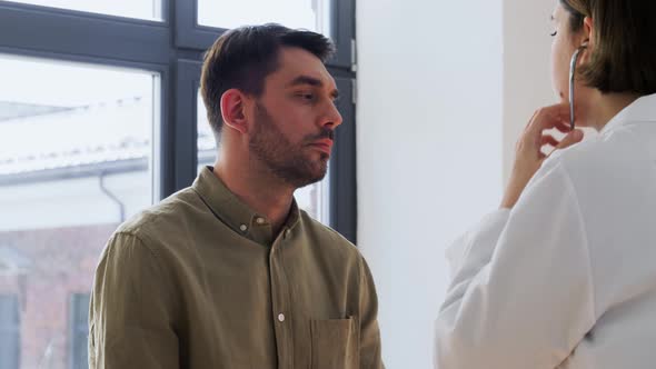 Doctor with Stethoscope and Man at Hospital