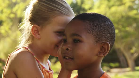 Girl Whispering Secret Into Boys Ear