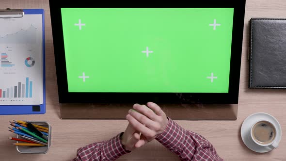 Top View of Male Fingers Zooming in and Out a Green Screen Monitor