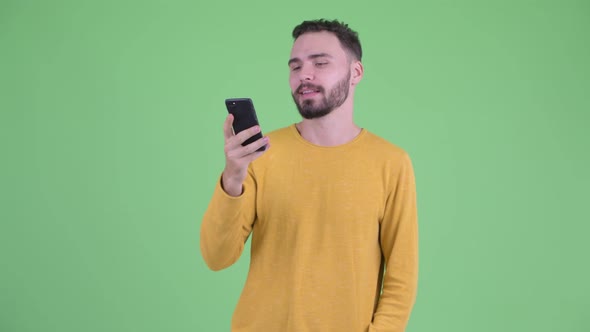 Happy Young Handsome Bearded Man Talking on the Phone