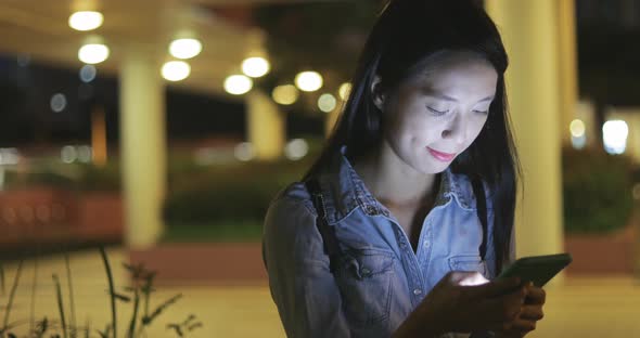 Woman concentrate on using mobile phone at night 