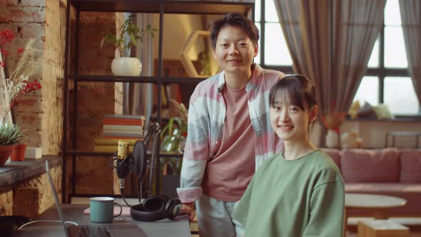 Portrait of Two Cheerful Asian Women at Home Recording Studio