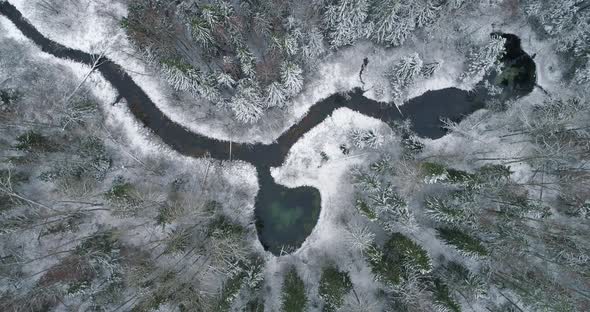 Spring Water Heart Shape Lake in Snowy Winter Forest Aerial Top View