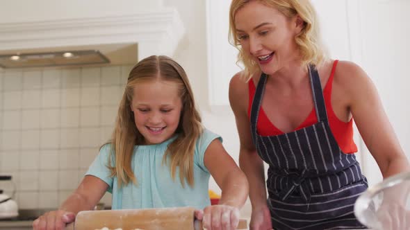 Caucasian mother and daughter baking together in the kitchen at home