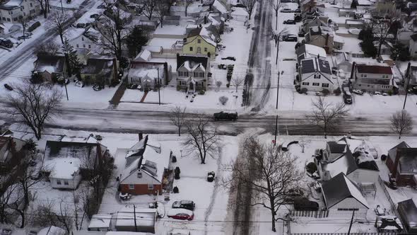 an aerial view over a suburban neighborhood in the morning, after a snow storm. The drone camera dol