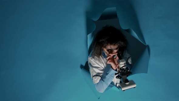 Crazy Foolish Scientist Using Laboratory Microscope in Studio