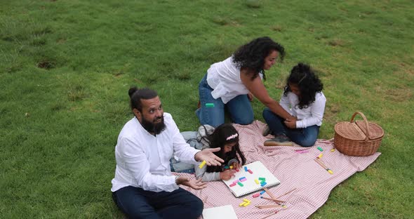 Indian parents having fun at city park playing with wood toys with their children