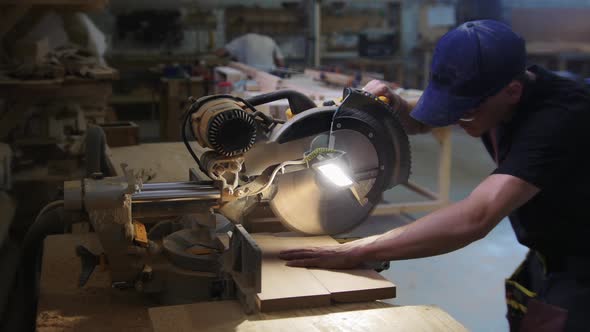 Carpentry Works in Workshop Man Worker Cutting the Pieces of the Wooden Desk Using a Big Circular