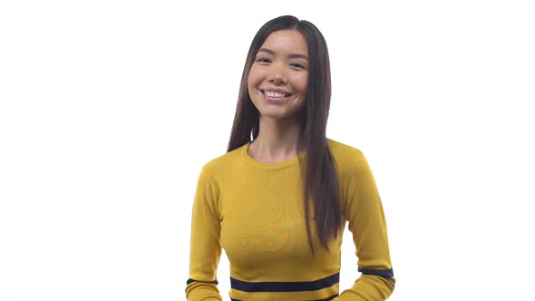 Slow Motion Pleasant Happy East Asian Girl Yellow Cropped Top Smiling Friendly Expressing Positive