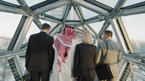 Multi-Ethnic Business Team Walking Along Glass Bridge