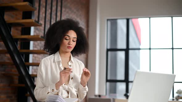A Young Biracial Woman Is Using a Laptop for Video Connection Indoor