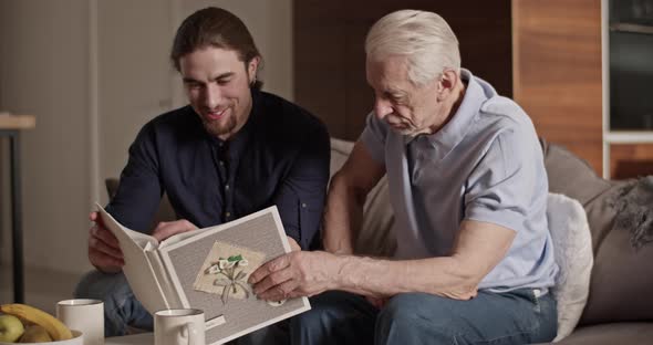 Father and Son Examining Photos Together