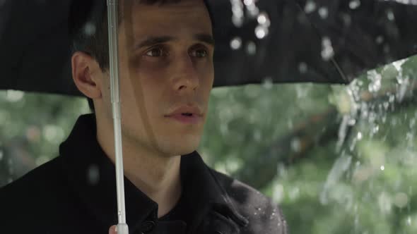 Man Under Umbrella at the Funeral