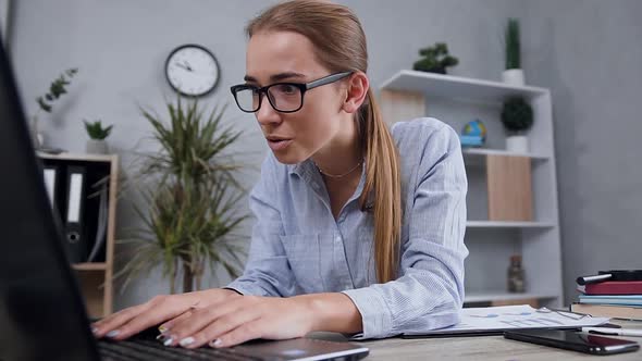 Blond Girl in Glasses Looking at the Computer Screen and Smiling From Seen Result