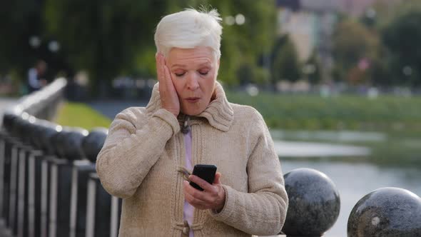 Mature Woman Texting Messaging on Modern Smartphone Gadget Gets Read Unexpected News Surprised