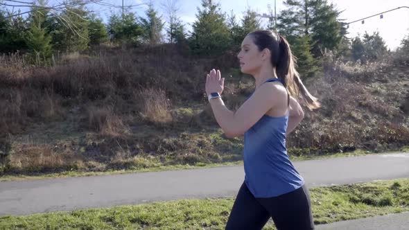 Fit young woman running in Winter slow-motion tracking