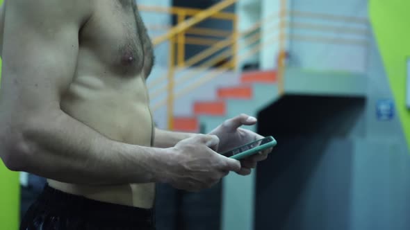 Close Up, Shirtless Man with Muscular Body Uses Mobile Phone for Online Training Program