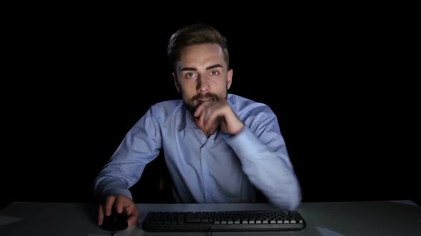 Man Excitedly Looking at a Computer Monitor. Dark Studio