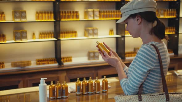 Beautiful girl choosing a perfume in a store