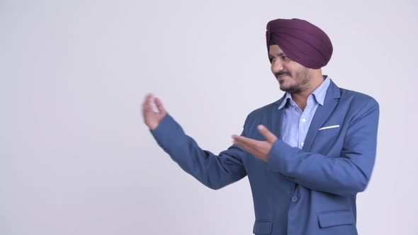 Happy Bearded Indian Sikh Businessman Showing Something