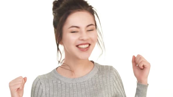 Happy Caucasian Brunette Teenager Girl Rejoicing on White Background and Saying Yes in Slowmotion