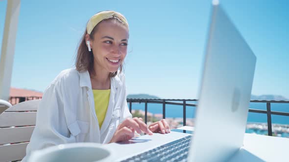 Pleased Woman Enjoying Morning Coffee While Sitting on Terrace with Sea View on Turkish Resort Using