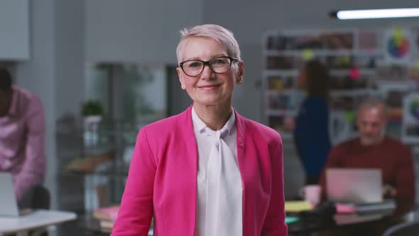 Portrait of Stylish Senior Businesswoman Smiling at Camera Standing in Creative Office