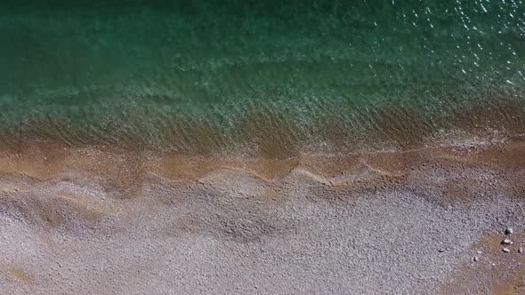 Aerial View From Above on Azure Sea and Pink Pebbles Beach