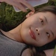 Young Asian Woman Lying on the Green Grass - VideoHive Item for Sale