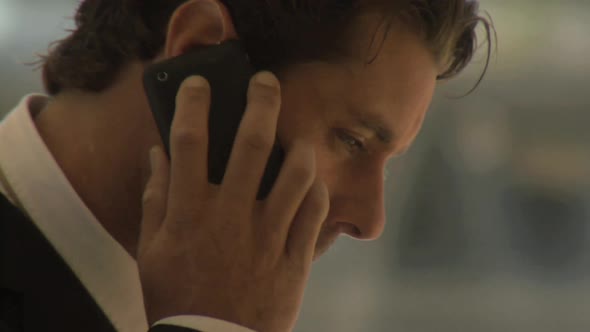 CU OF A BUSINESSMAN USING A CELL PHONE