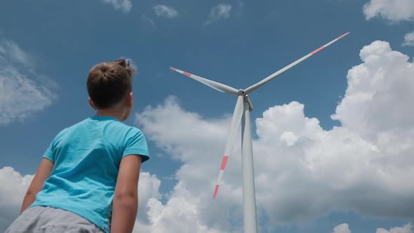 Boy against the background of windmills farm. Power Energy Production in Montenegro.