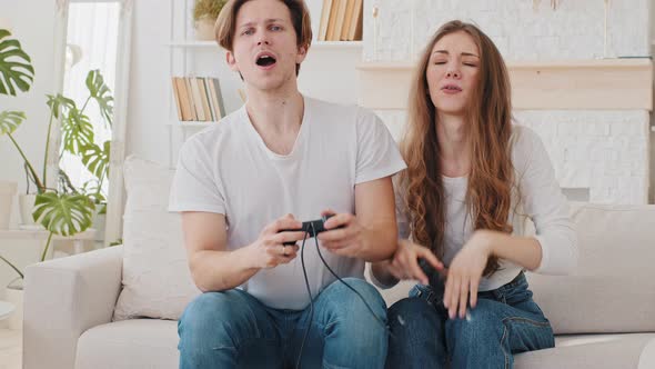 Married Couple Caucasian Woman and Millennial Man Boyfriend and Girlfriend Playing Console Online