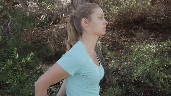 A young woman runner stretching before her run.