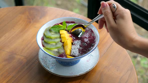 Woman Hand Rotate Vegan Smoothie Bowl with Fresh Fruits Healthy Breakfast