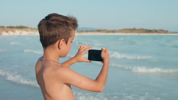 Joyful Boy Looking to Screen at Seaside