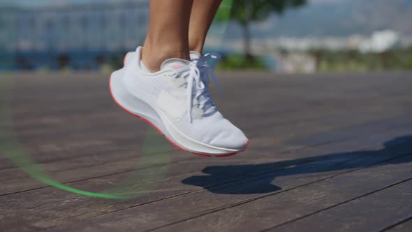 Young Woman Jumping Rope in the Rays of the Sun