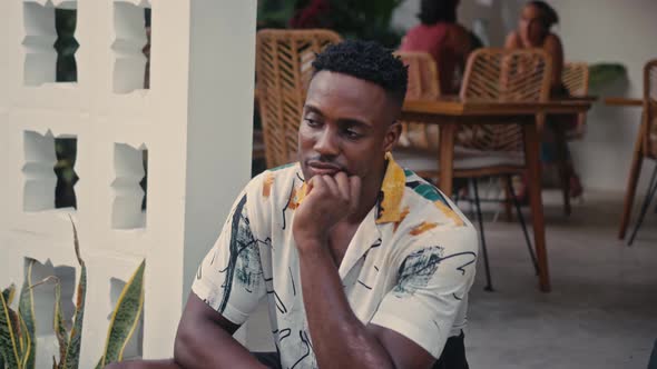 AfricanAmerican Man Smiles While Standing in a Coffee Shop