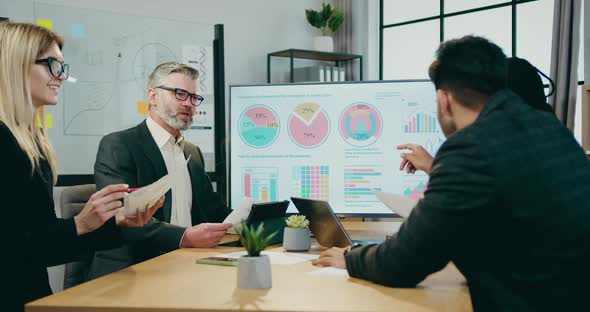 Multiracial Businesspeople Brainstorming Together over Business Strategy of Company During Meeting