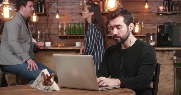 Young Freelancer Working at His Laptop Being Served Coffe and Croissant at Breakfast