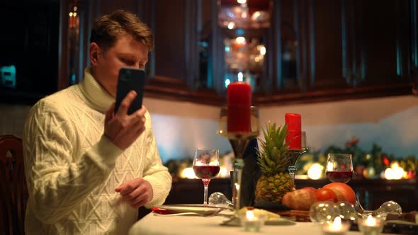 Sad Man Talking on Phone Hanging Up Blowing Out Candle on Table with Romantic Dinner