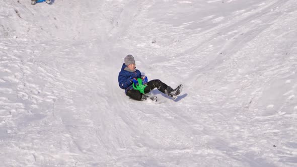 Frost winter season. Two children ride down a hill, winter games and fun. 