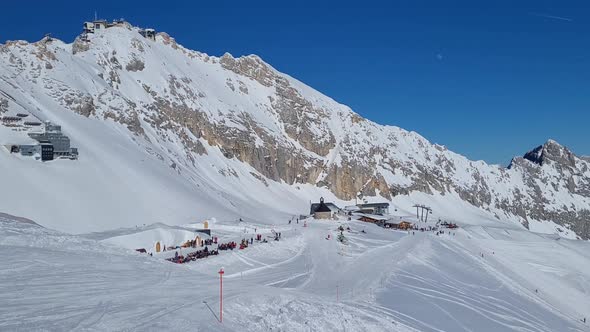 Panorama of ski resort in the german alps. Skiers on a ski slope on a sunny winter day.